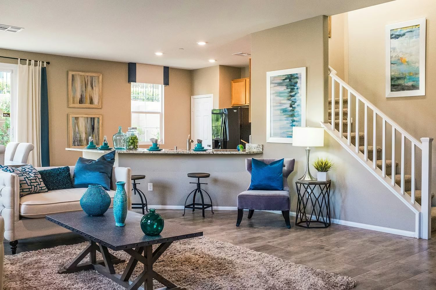 A tidy family living room and kitchen with a breakfast bar and staircase